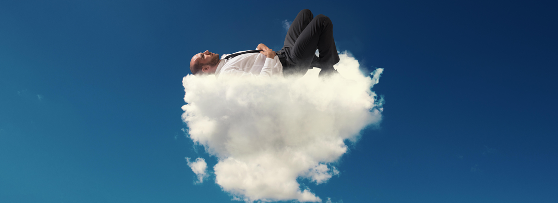 Ein Mann in einem Geschäftsanzug, der auf einer flauschigen Wolke schläft